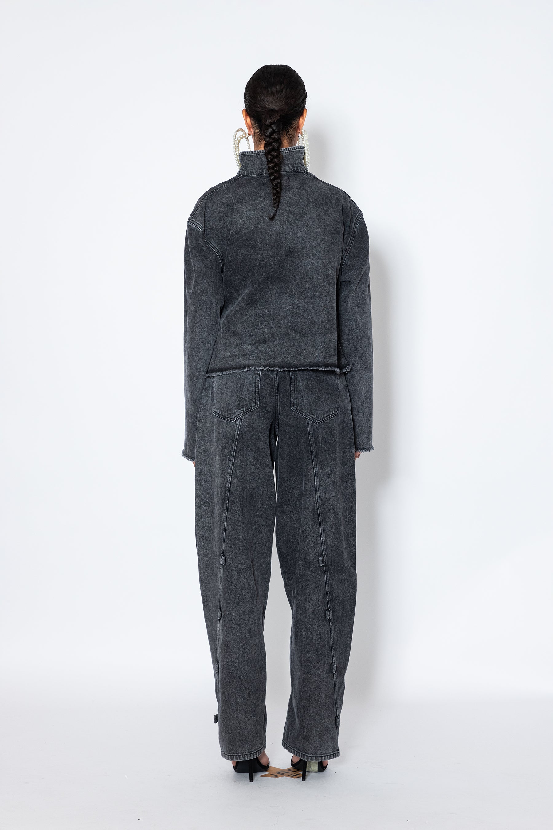 model shows Jade Cropper asymmetric denim jacket with piercings back view gray long sleeves distressed hem