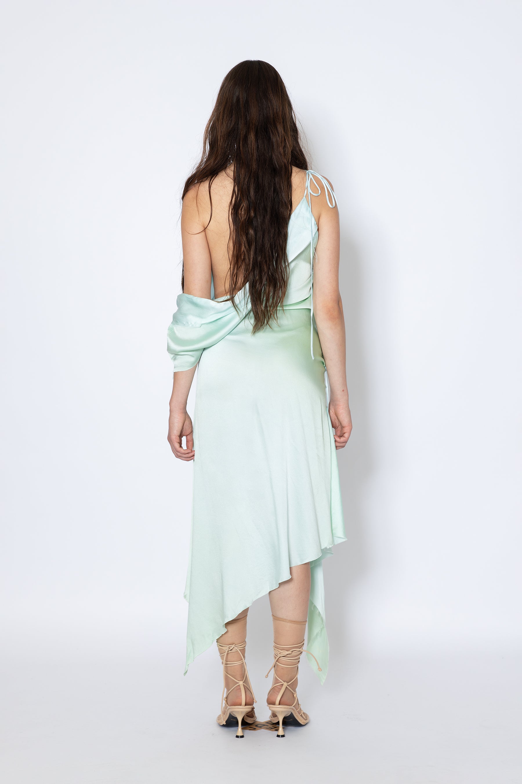 Model shows Jade Cropper silk fabric asymmetric hem raw edge tie detail on back view
