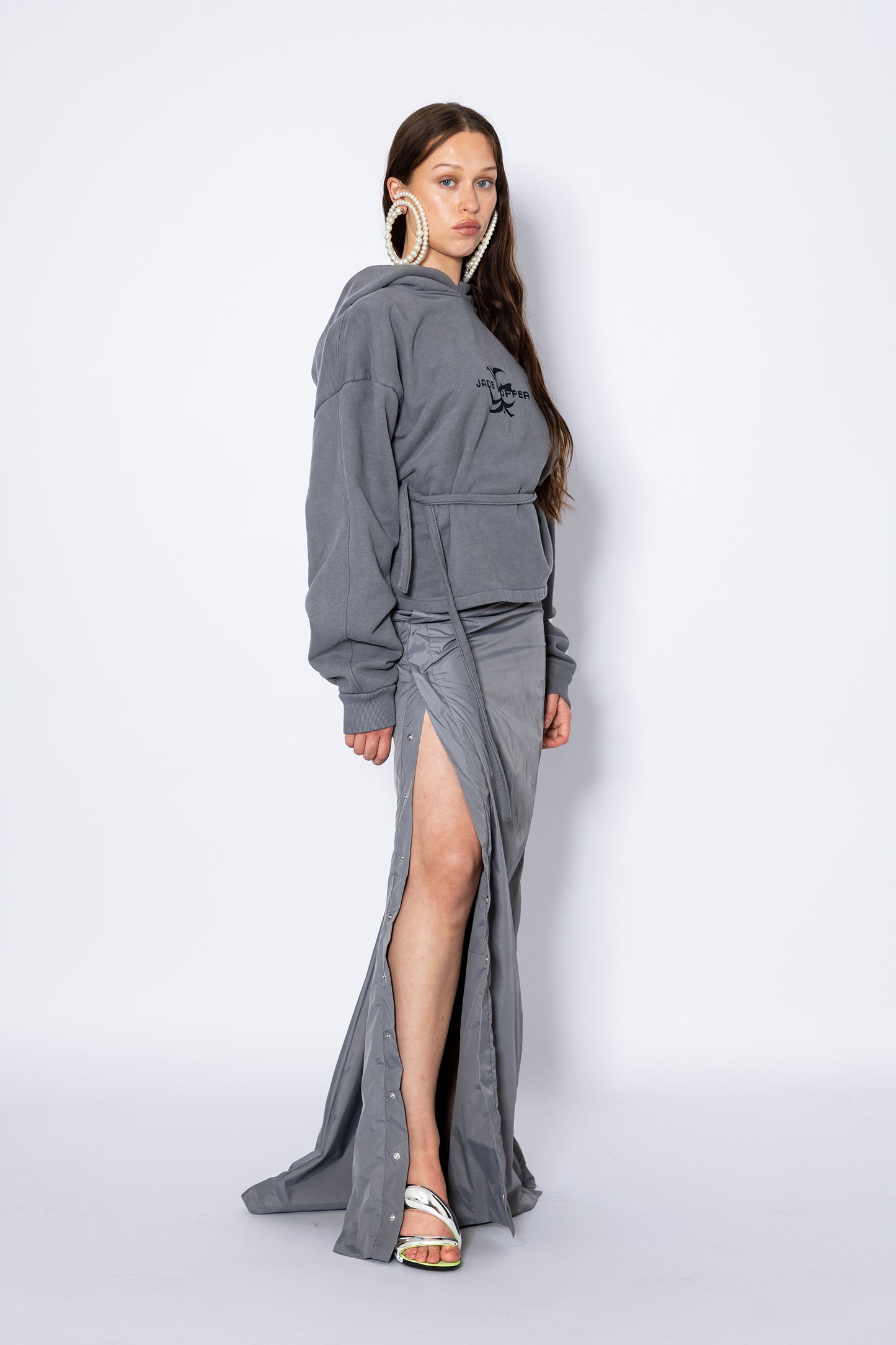 Side view of Jade Cropper Hooded Sweater With Open Back gray with hood, logo, drawstring, and long sleeves showing fit