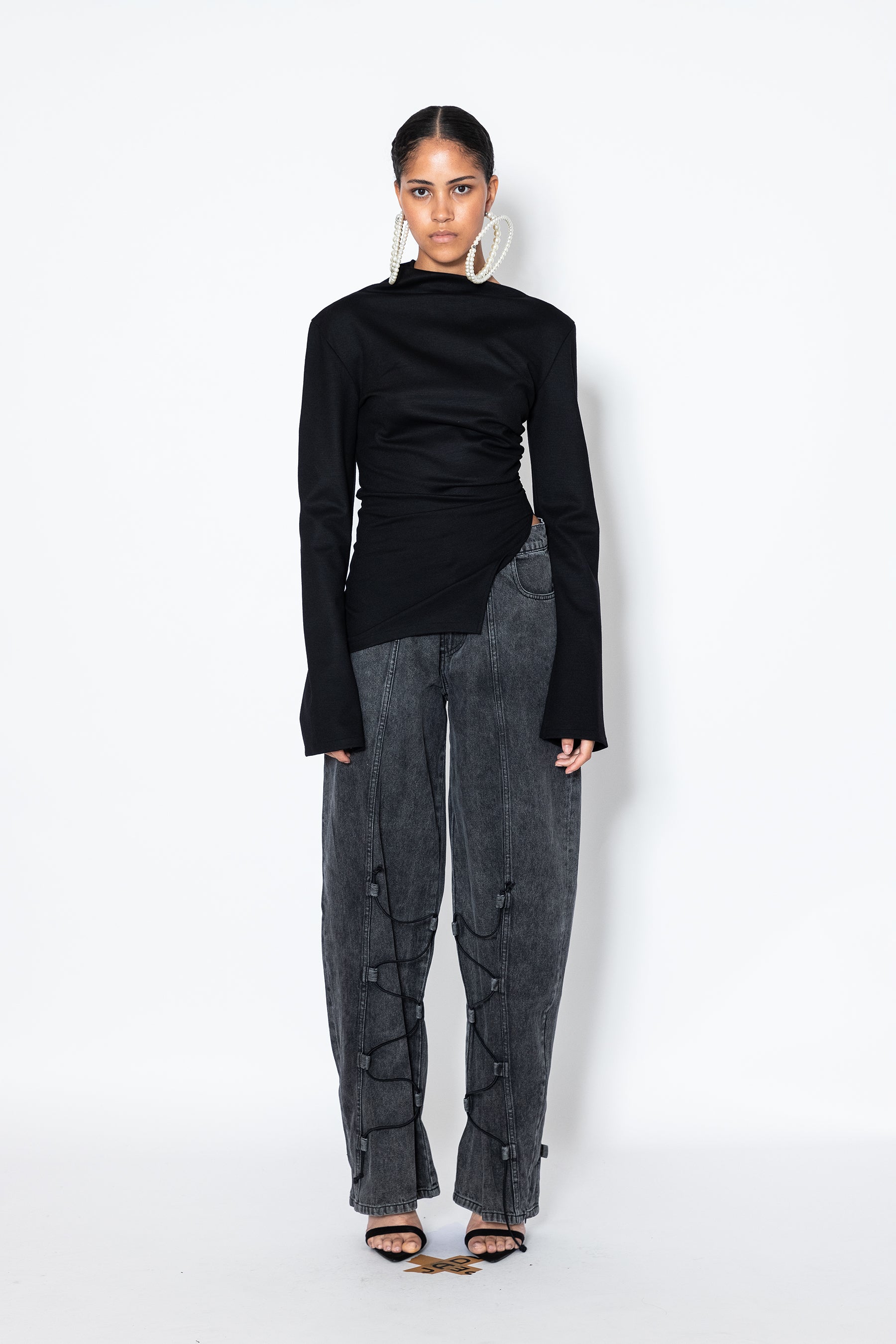 Model wears Jade Cropper Asymmetric Top With Slit in black featuring high neck asymmetric hem and slit front detail