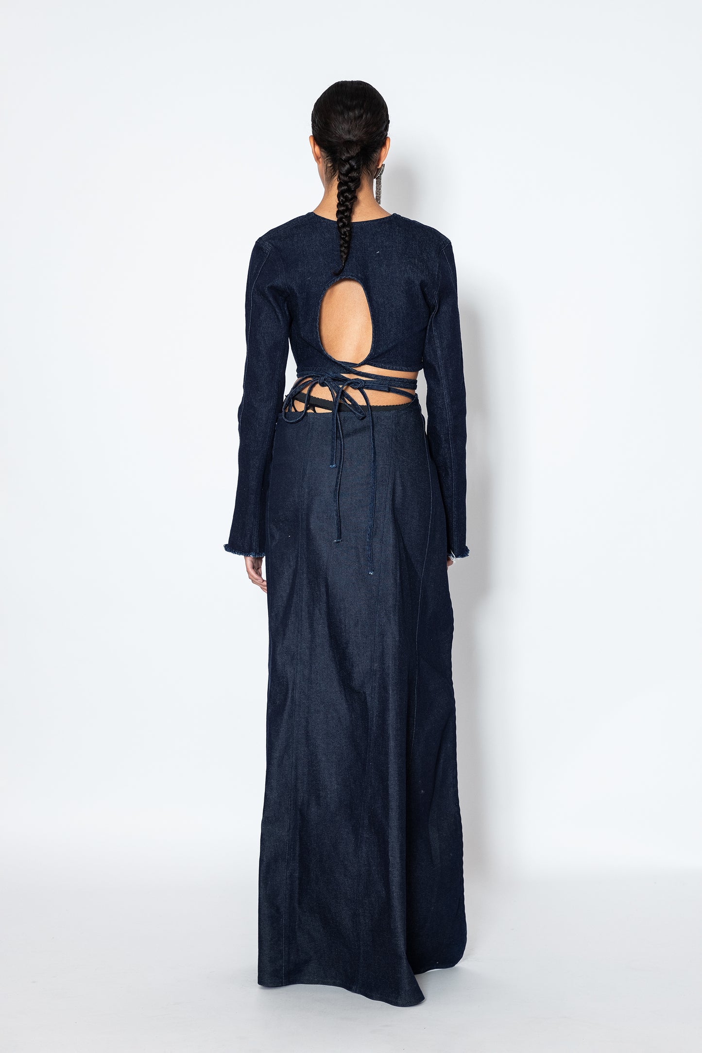 back view of model in jade cropper navy denim top with open back tie detail and long sleeves
