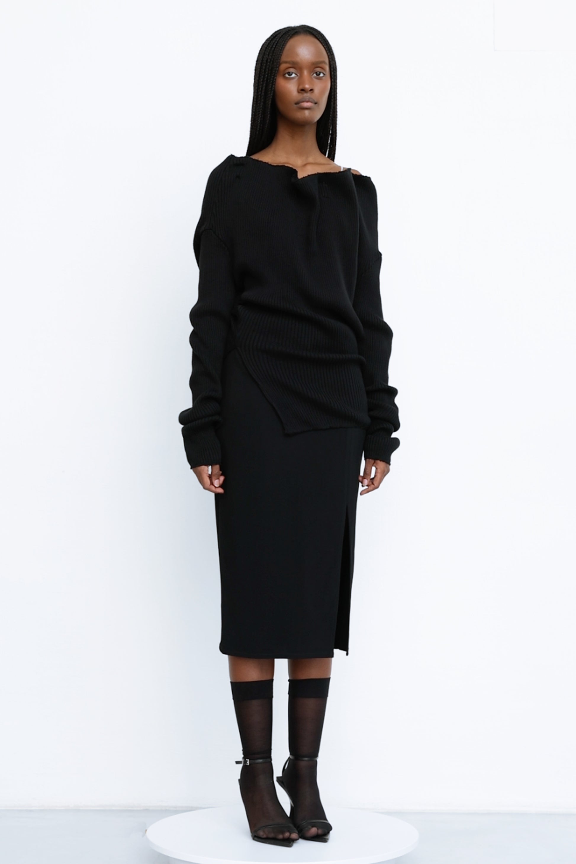 Front view of Jade Cropper black ribbed top with drop shoulder asymmetric hem and cut-out detail