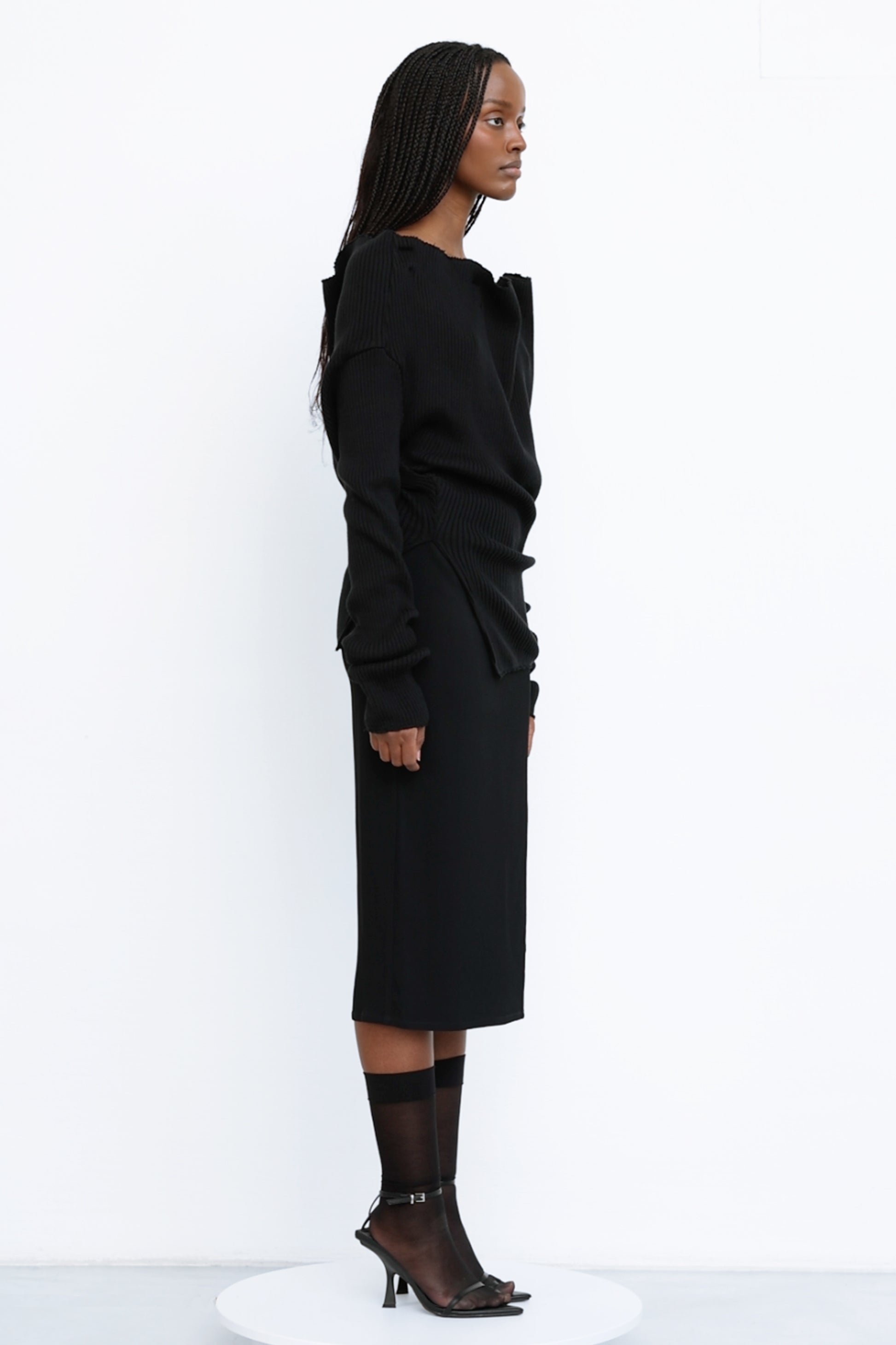 Side view of Jade Cropper ribbed texture black top with long sleeves crew neck and asymmetrical hem