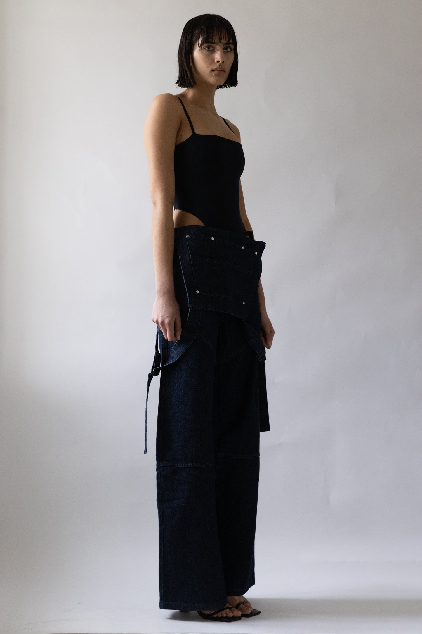 Side profile of Jade Cropper Garden Trousers in blue denim showing high waist, wide leg, cut-out detail and contrast stitching