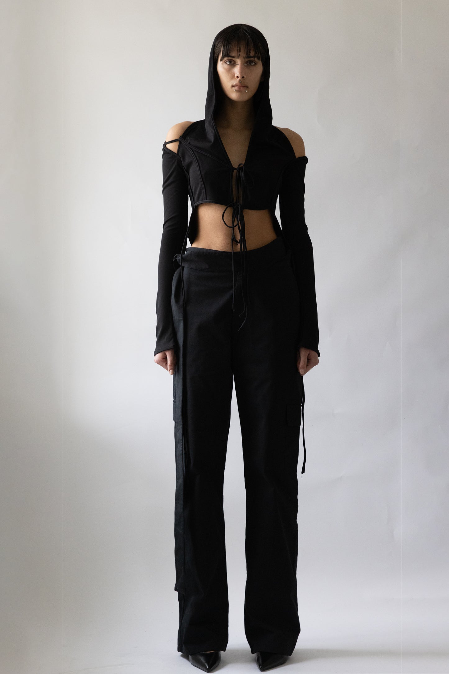 Front view of black Jade Cropper Hooded Cardigan With Straps featuring hood, cut-out shoulders, tie front, and long sleeves