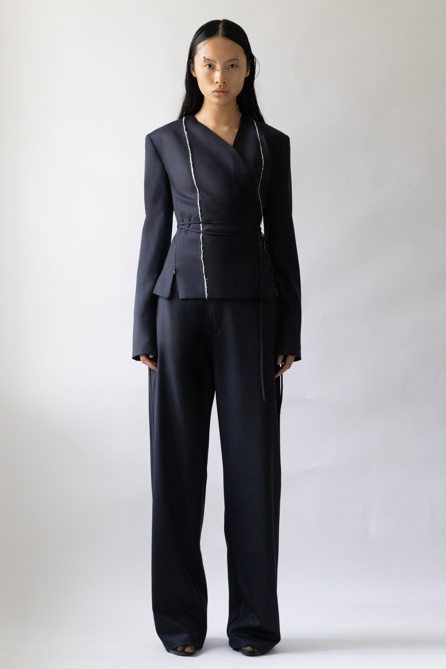 Jade Cropper garment with wrap design navy fabric long sleeves contrast stitching wide leg front on model