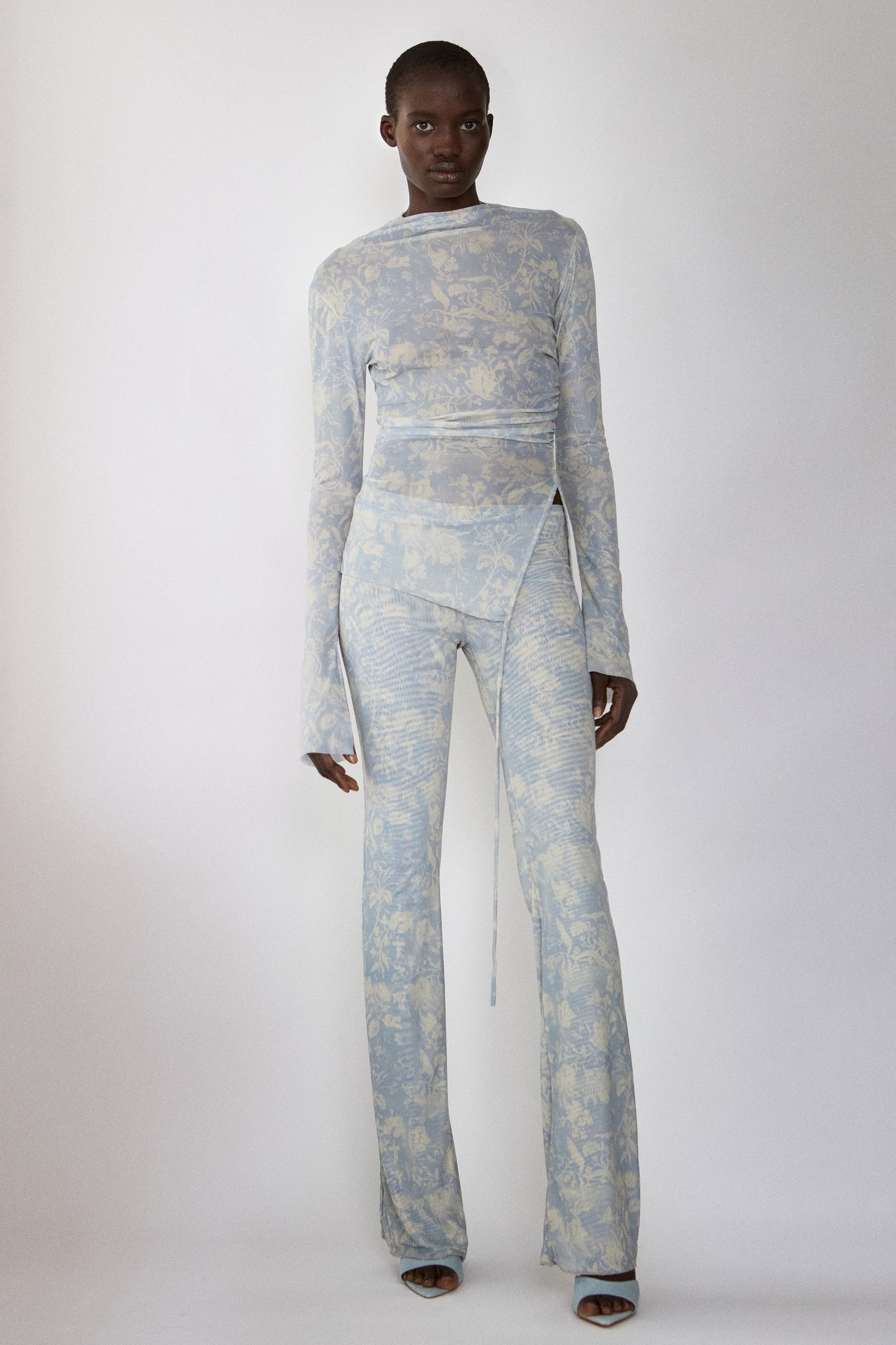 Model wearing Jade Cropper wrap design front view with long sleeves, flared legs and bold print