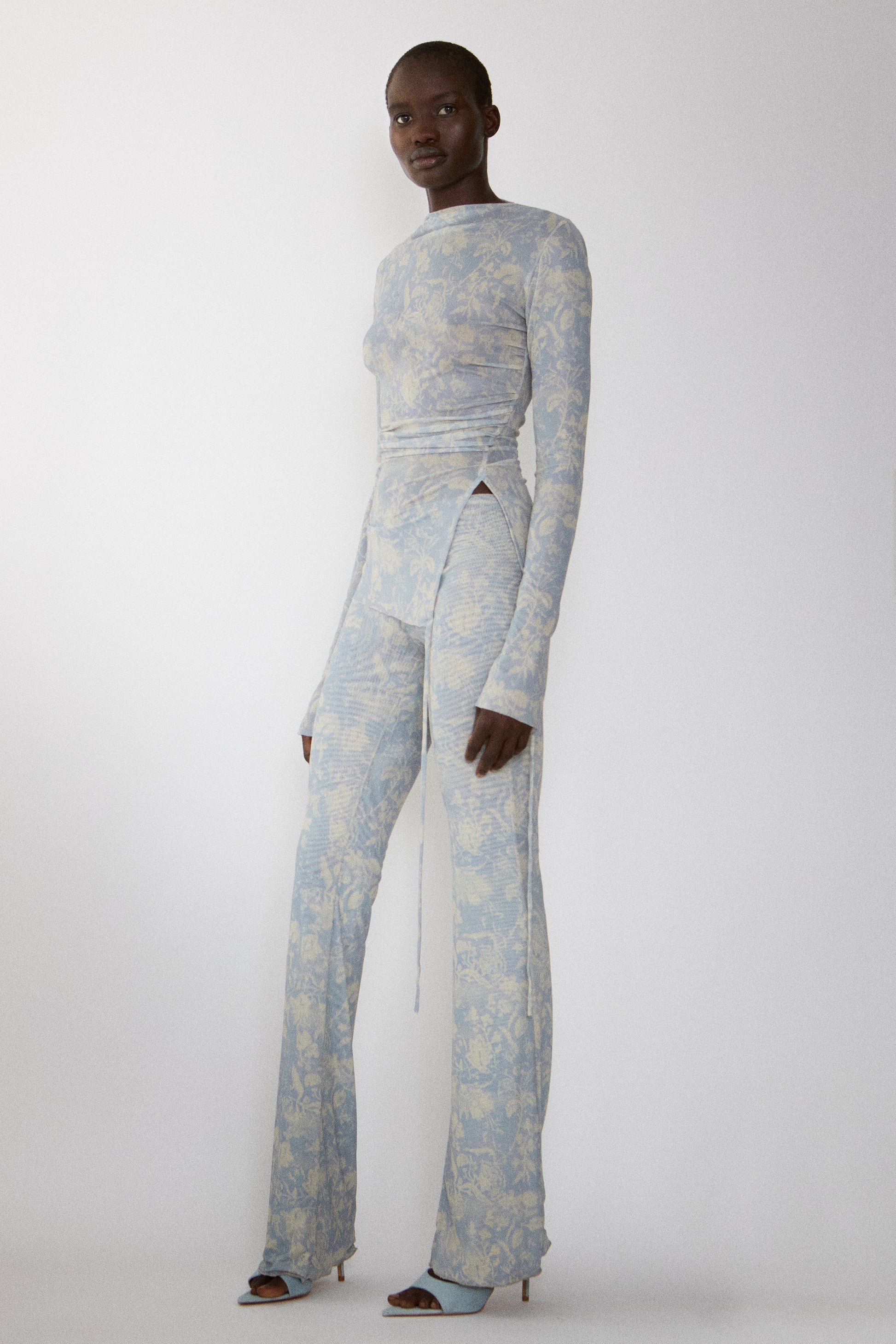 Model wears Jade Cropper Draped Top With Slit front view with side cutout long sleeves high waist and flared legs