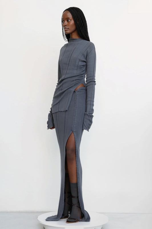 Model wears Jade Cropper knitted maxi skirt with hook and eye grey front view ribbed texture high slit asymmetrical cut