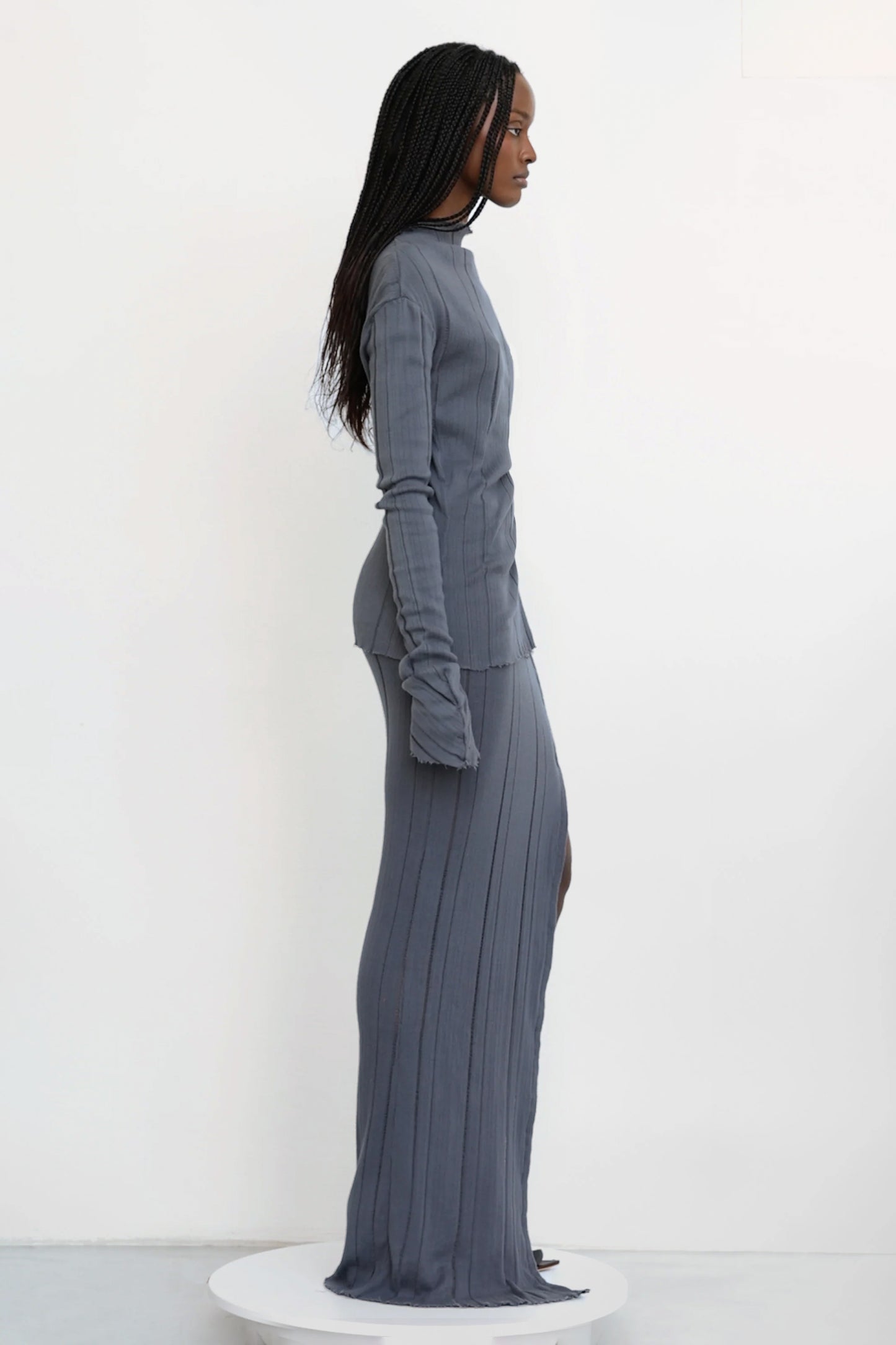 Model in Jade Cropper knitted maxi skirt with hook and eye grey side view fitted silhouette ribbed texture side slit long length