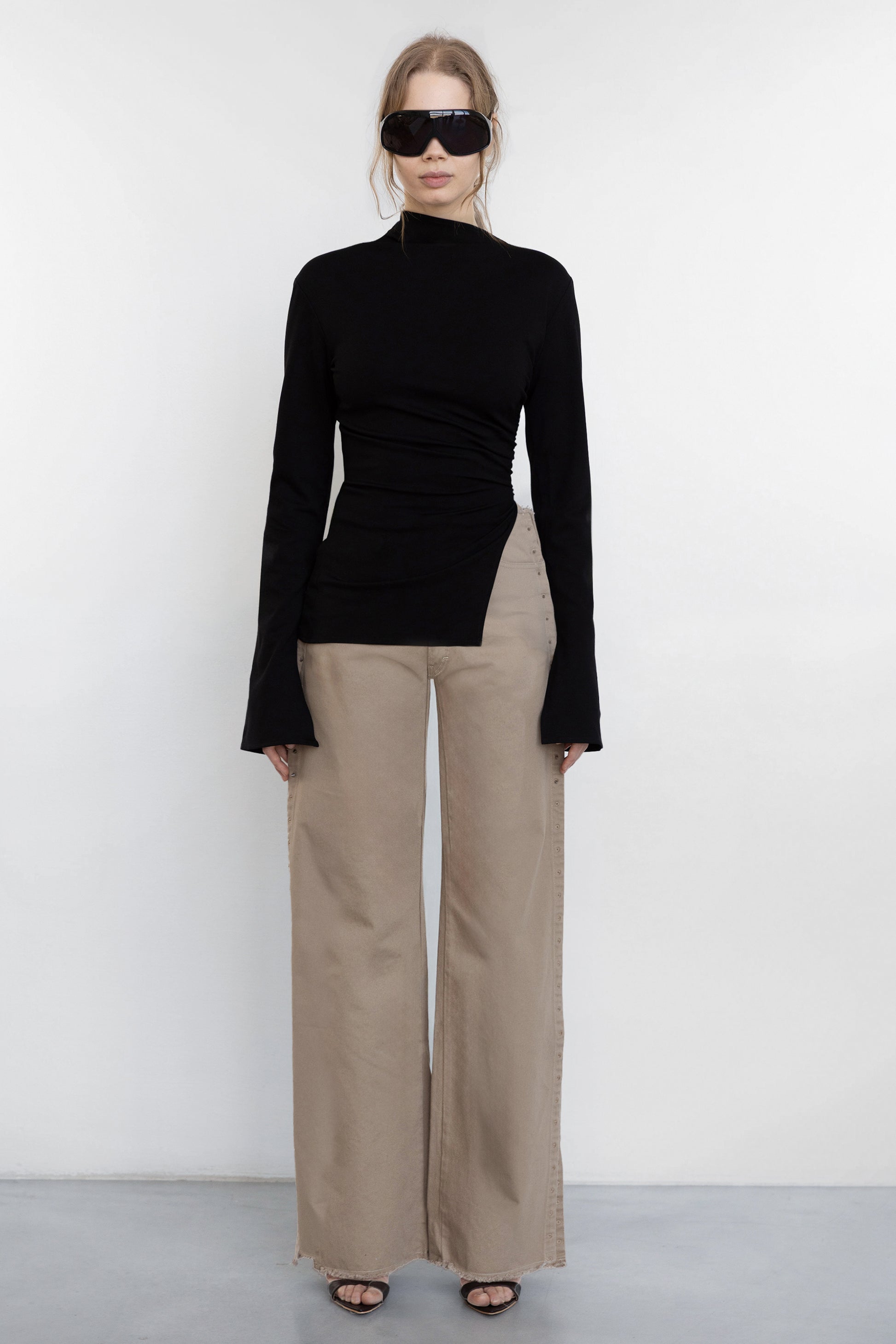model wearing Jade Cropper beige wide leg pants with raw hem and piercing detail front view