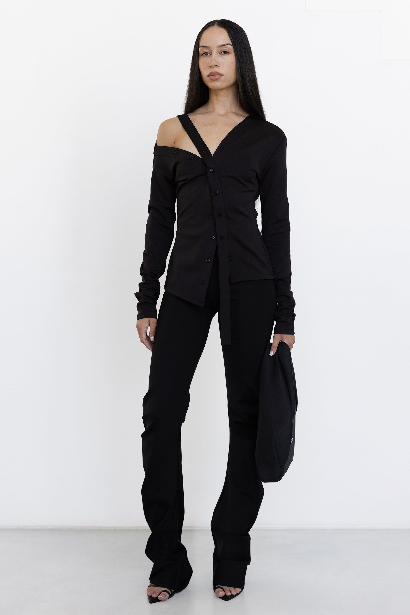 Jade Cropper Asymmetric Off Shoulder Top in black front view features off-shoulder, button details, long sleeves, and waist tie