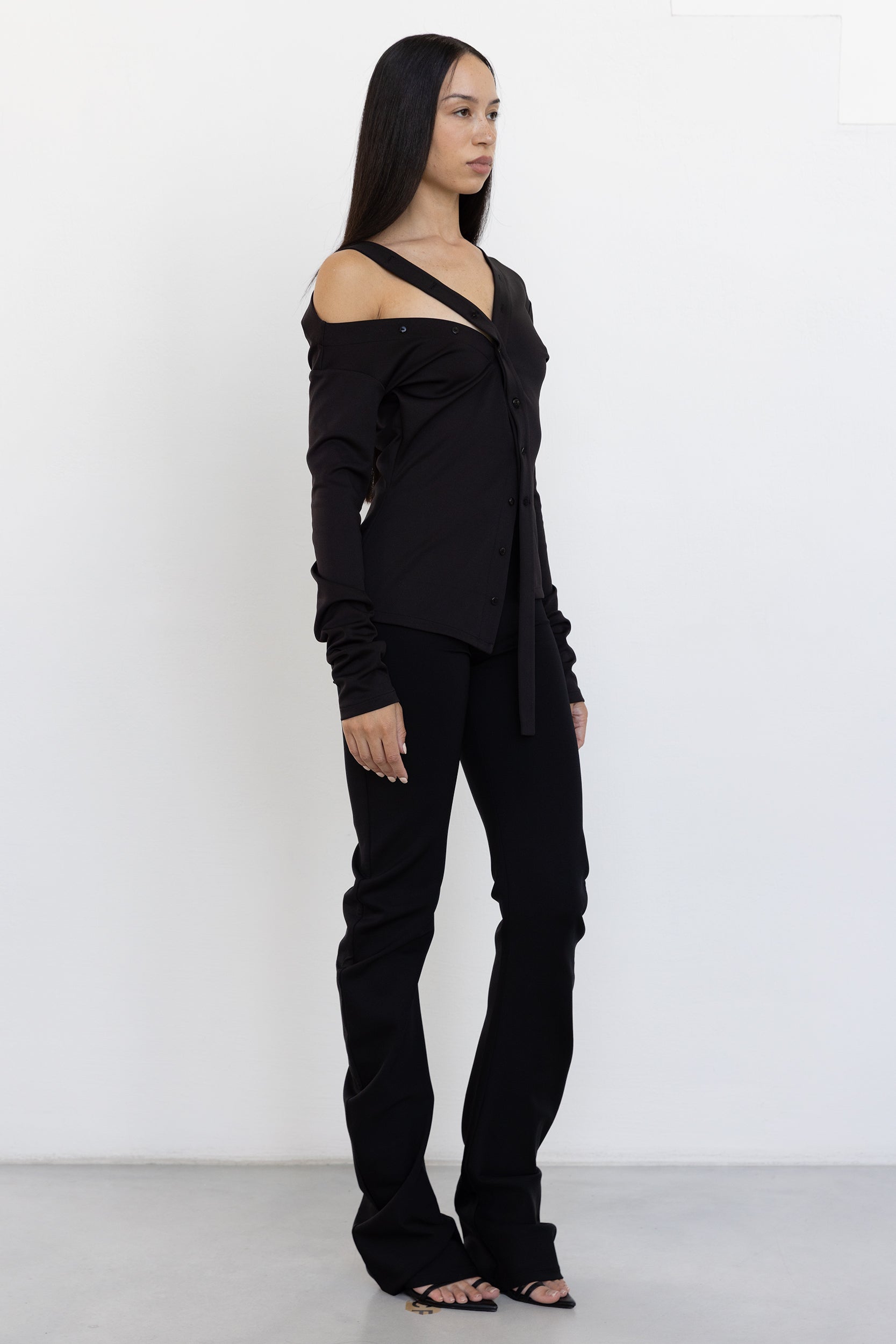 Jade Cropper Asymmetric Off Shoulder Top black side view highlights off-shoulder silhouette, long sleeve, buttons, and tie features
