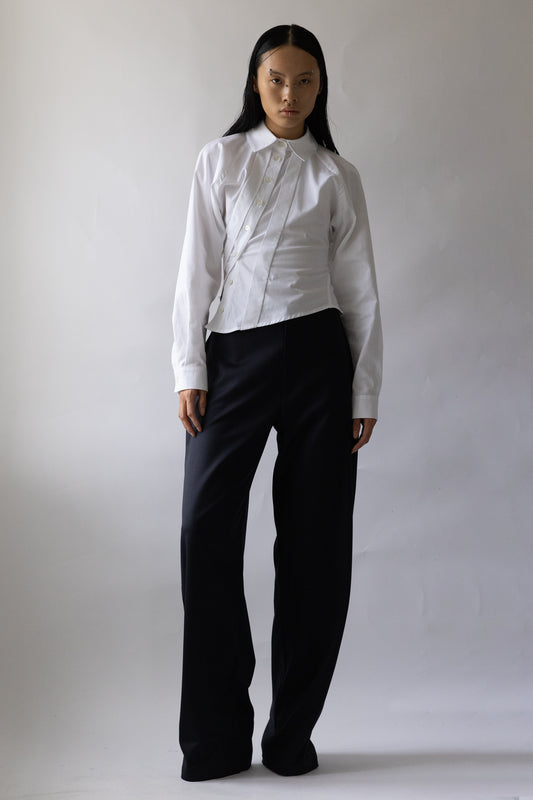 Model wears Jade Cropper Asymmetric Shirt White with fitted silhouette button front long sleeves and collared neckline front view