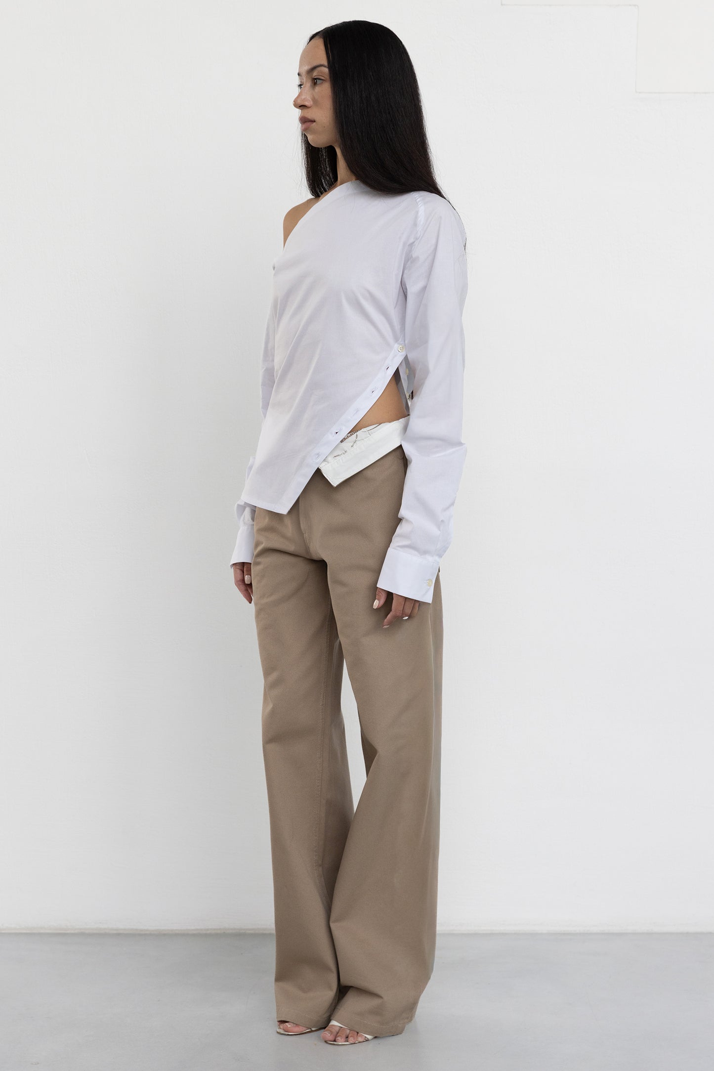 Jade Cropper white off-shoulder garment with button details asymmetrical hem and long sleeves side view