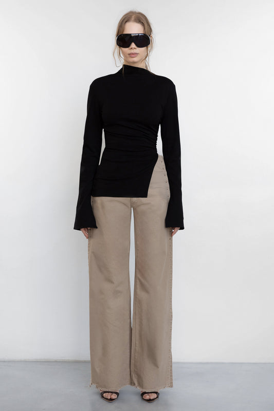 model wearing Jade Cropper beige wide leg pants with raw hem and piercing detail front view