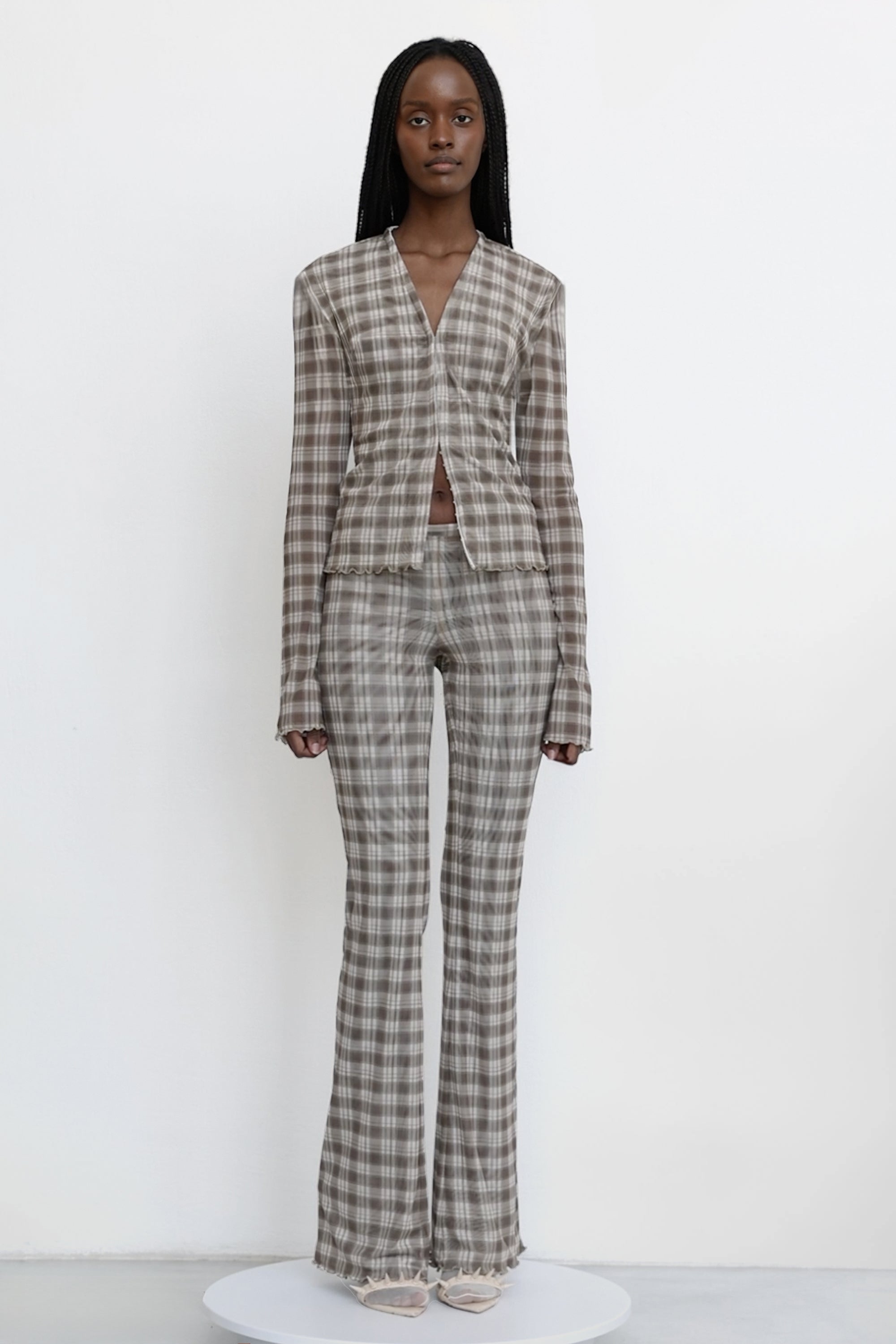 Model wears Jade Cropper garment with gray plaid pattern long sleeves v-neck and scalloped hem front view